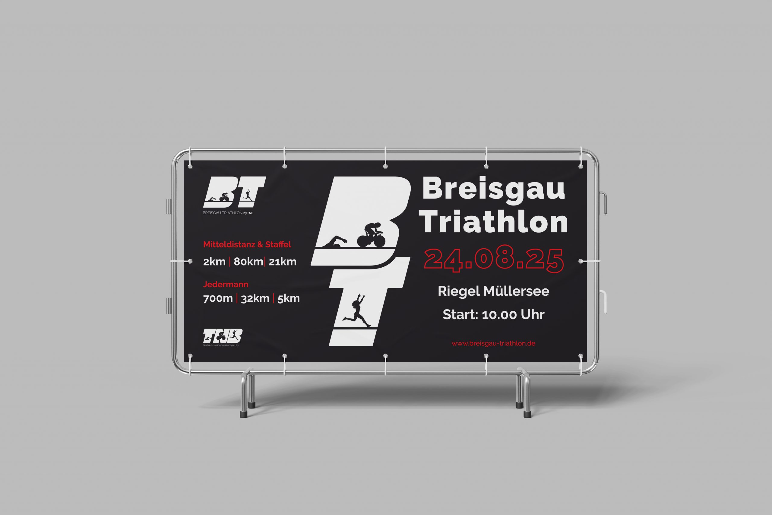 Bauzaunbanner für den Breisgau Triathlon 2025: Schwarzes Banner mit weißem ‚BT‘-Logo, Streckeninformationen (Mitteldistanz: 2 km | 80 km | 21 km, Jedermann: 700 m | 32 km | 5 km), Datum (24.08.2025), Ort (Riegel Müllersee) und Startzeit (10:00 Uhr). Entworfen von Rebekka Markert, Grafikdesigner:in für Sport-Event-Werbung